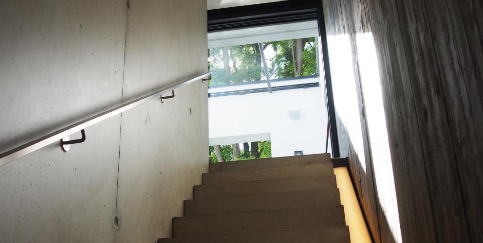 Projet CS - L'escalier menant au sous-sol confronte béton lisse et béton brute dans un jeu de matière subtil
